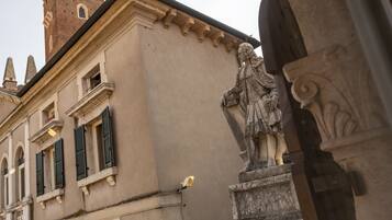 Un edificio storico con una torre, una statua e un arco in pietra.