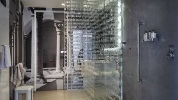 A modern bathroom with a glass partition, a sink, and a shower area.