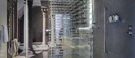 A modern bathroom with a glass partition, a sink, and a shower area.