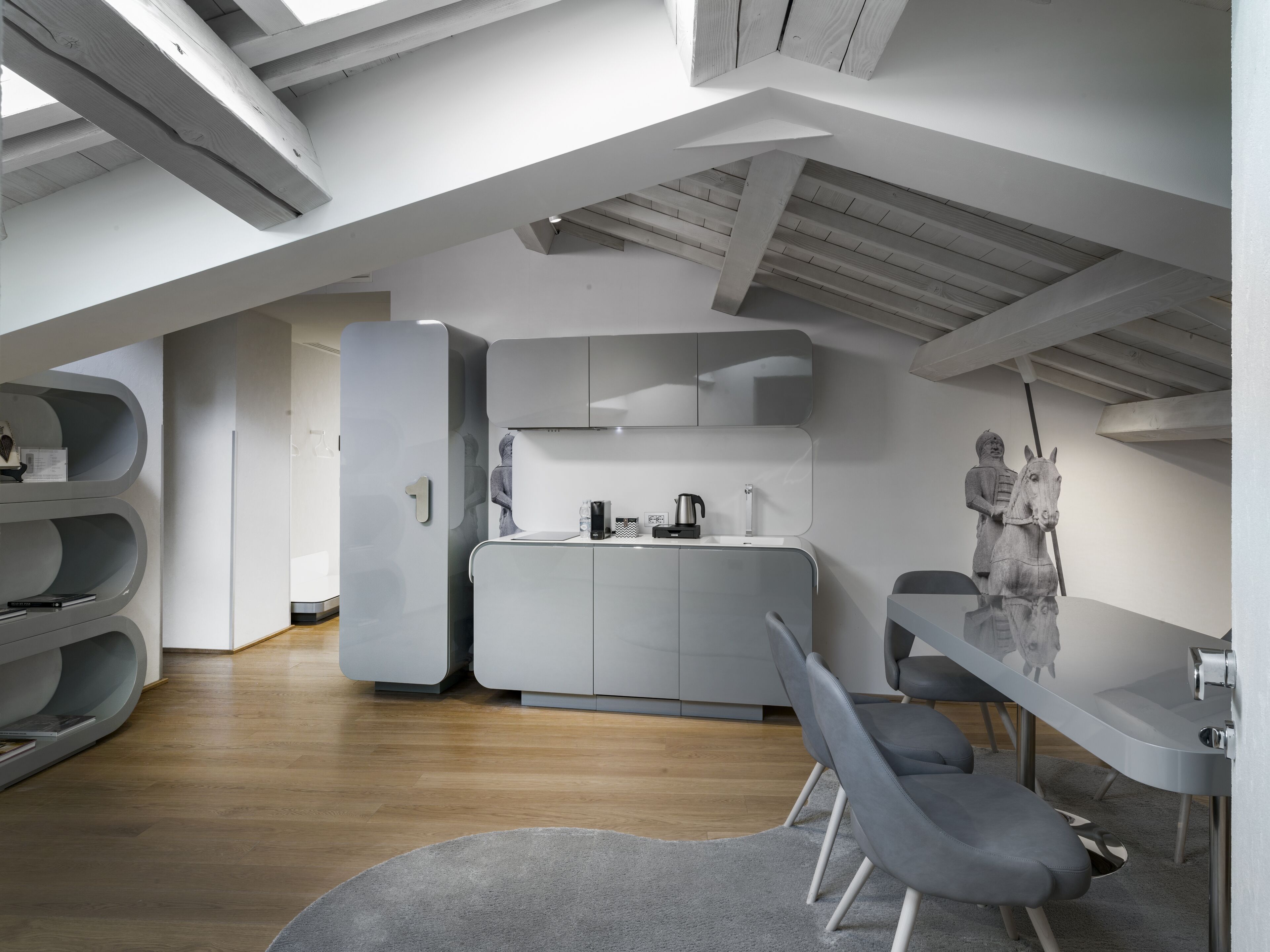 Eine moderne Loft-Wohnung mit Küche, Essbereich und großem Fenster.
