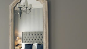 Una camera da letto con una testiera trapuntata, un letto con copriletto a scacchi e un comodino con lampada.