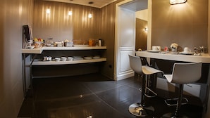 A modern bathroom with a vanity, a mirror, and a seating area with two chairs. - Villa San Martino (Naples)