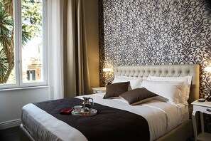 A neatly made bed with a dark brown bedspread, white pillows, and a tray with a cup and a small pitcher. - Villa San Martino (Naples)