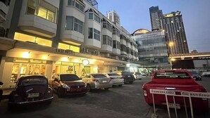 A hotel with multiple floors and a modern design, featuring a prominent sign for the "EASE HOTEL." - Ease Hostel (Bangkok)