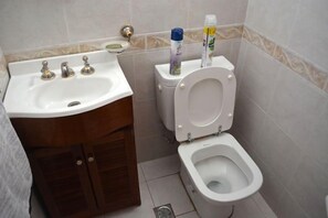 Ein Badezimmer mit Waschbecken, Toilette und Schrank.