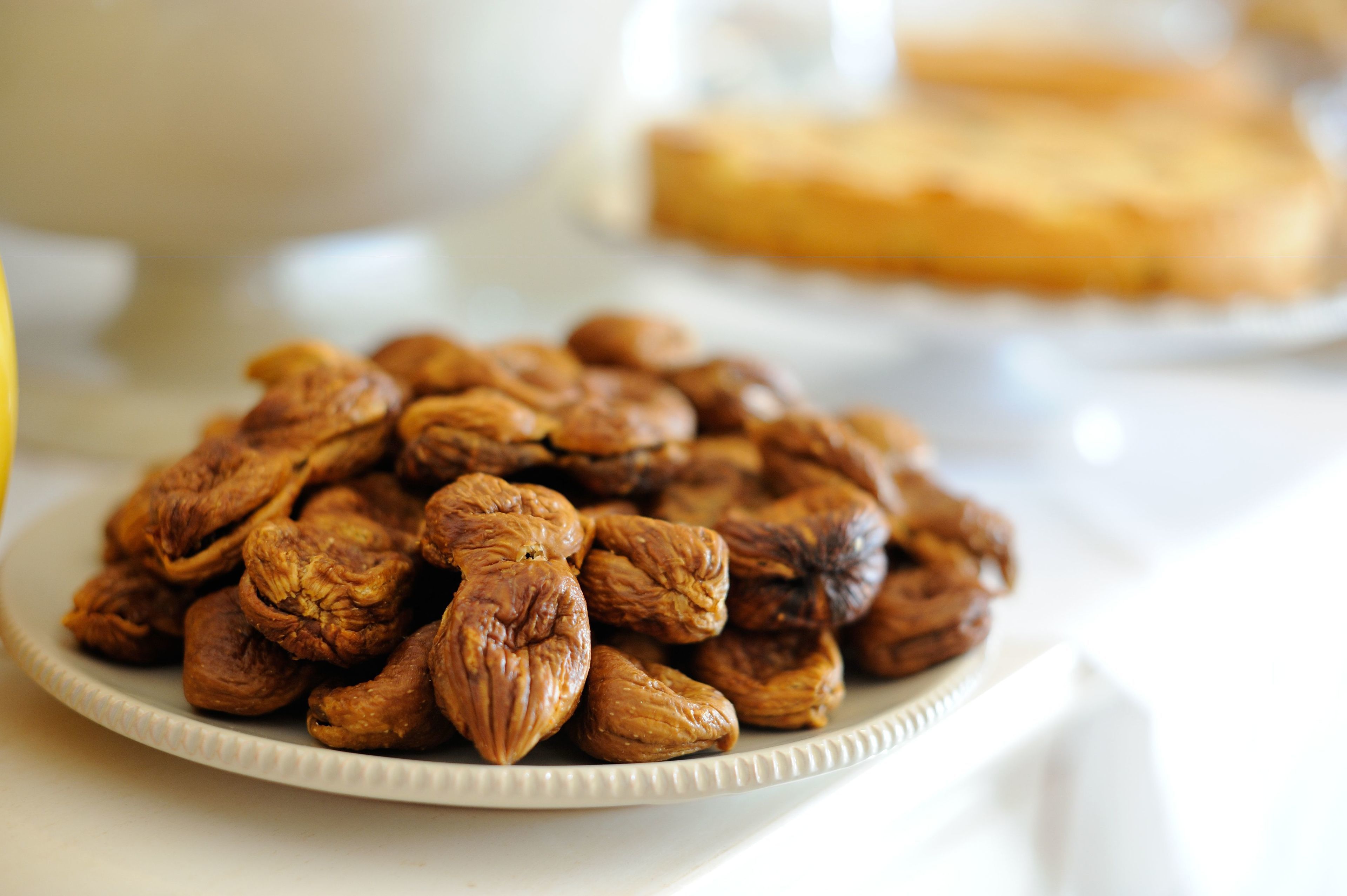Un plato de nueces sobre una mesa blanca.
