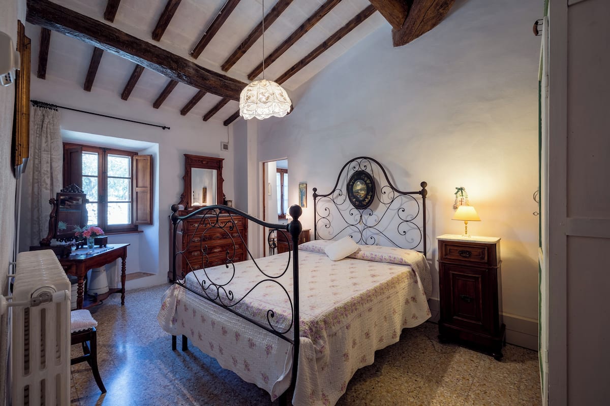 Une chambre à coucher avec un lit, une commode, un bureau et une lampe.
