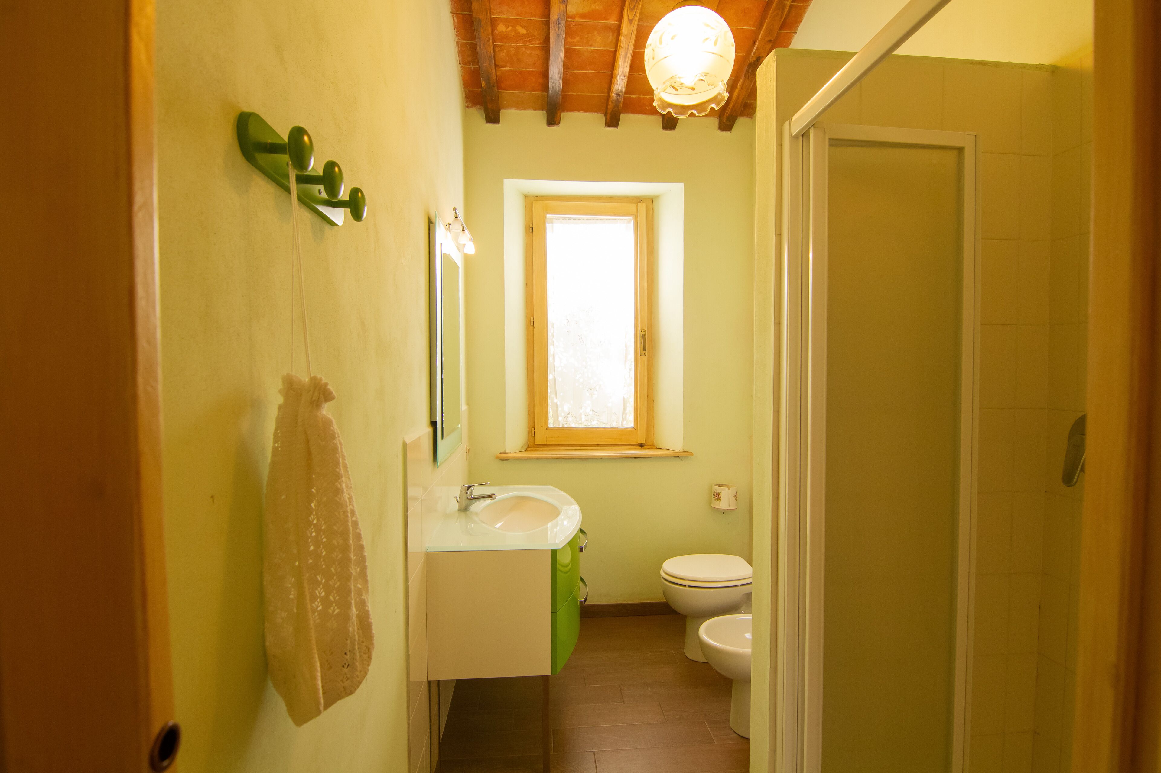 A narrow bathroom with a sink, mirror, and toilet.