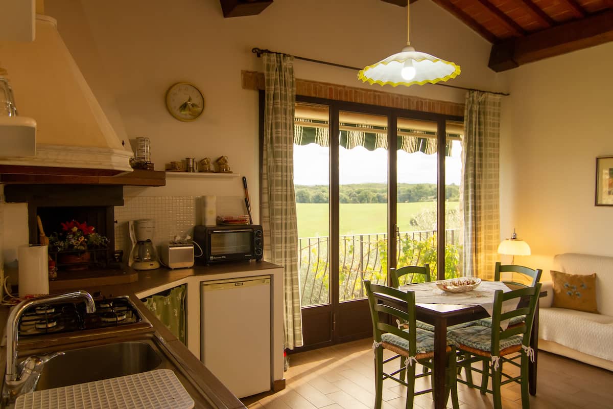 Une cuisine équipée d’un évier, d’une cuisinière, d’un four à micro-ondes et d’un coin repas avec une table et des chaises.
