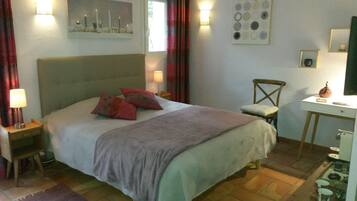 Una camera da letto con un letto, comodini, una scrivania e una sedia.