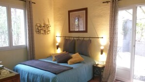 A bedroom with a bed, bedside lamps, a picture on the wall, and a window with curtains. - Les Mayombes (Roquebrune-sur-Argens)