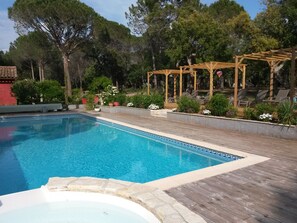 Una piscina al aire libre de temporada, sombrillas