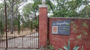 A gated entrance with a sign for 'Les Mayombes' featuring a tree illustration and contact information. - Les Mayombes (Roquebrune-sur-Argens)