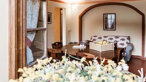 A cozy dining area with a wooden table, chairs, and a basket of fruits. - Tenuta degli Obizzi (Montecarlo)