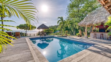 Una piscina al aire libre, sillones reclinables de piscina