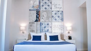 Un dormitorio con una cama grande, dos mesitas de noche y una pared decorada con azulejos azules y blancos.