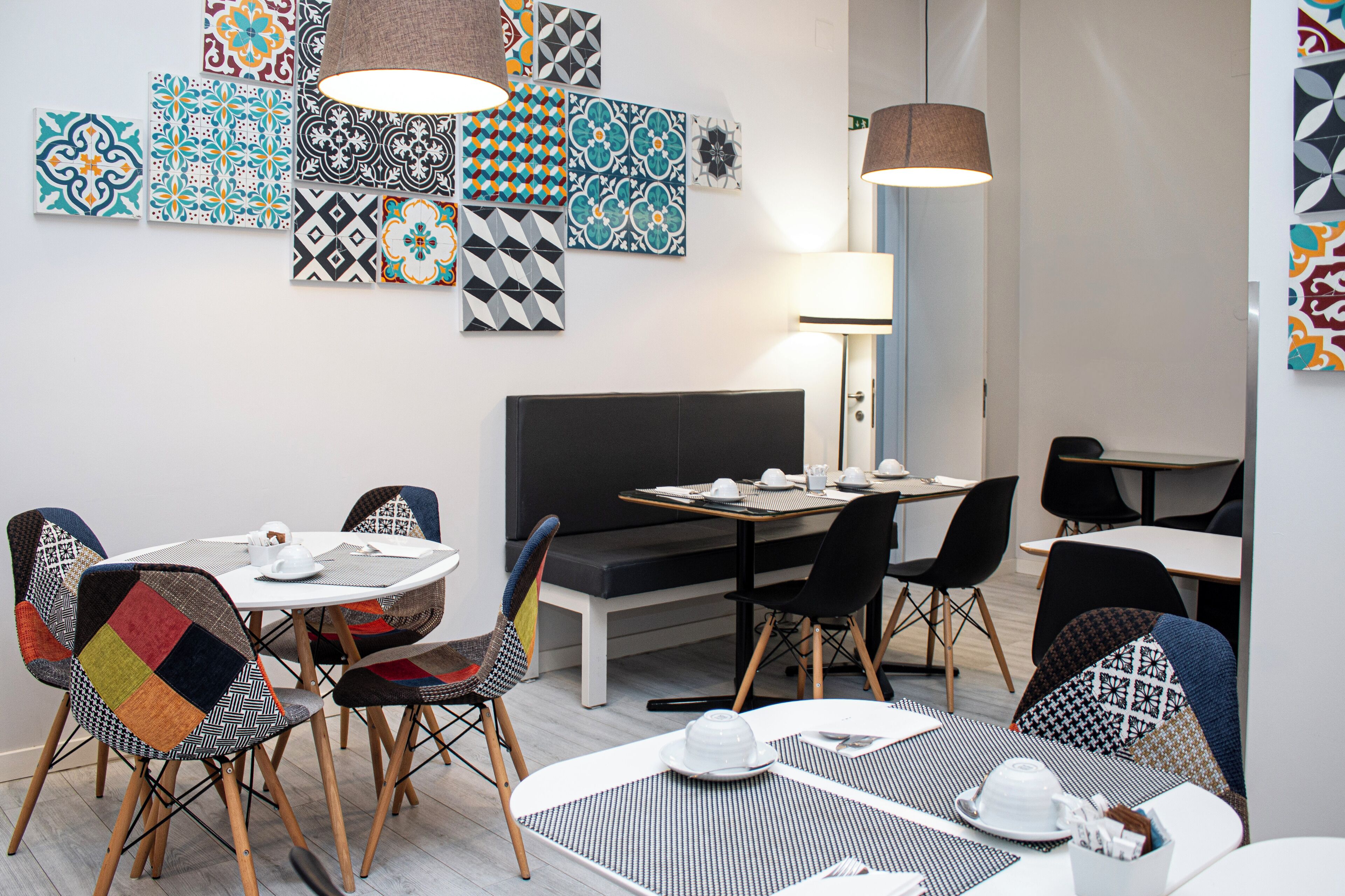 Uma sala de jantar moderna com uma mesa redonda, cadeiras e um banco.