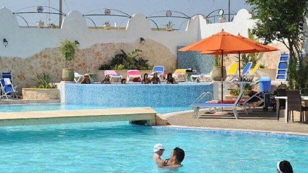 Ein Pool mit Liegestühlen und Sonnenschirmen.