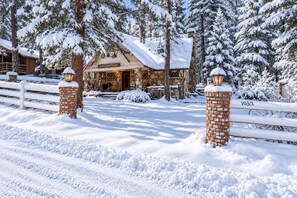A stone building with a sign reading 'Cornerstone' and a number '1032' on a snow-covered property. - Cornerstone Cabin (Big Bear Lake)