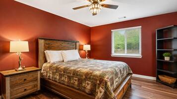 A bedroom with a wooden bed, two bedside tables, a ceiling fan, and a window with blinds.
