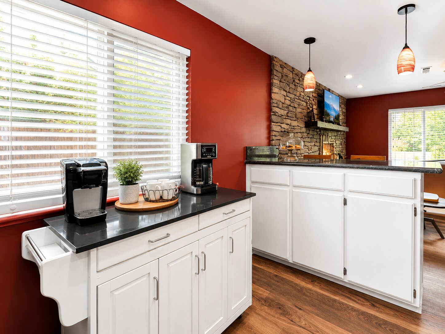 A kitchen with white cabinets, a stone backsplash, and a coffee maker on the counter.