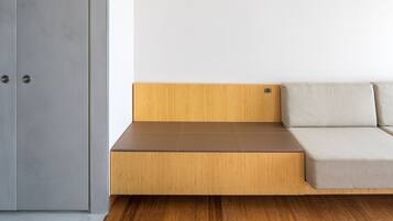 A room with a wooden bench and a grey wardrobe.