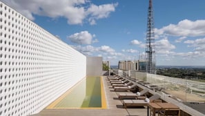 Relax by the pool on our rooftop terrace, surrounded by sun loungers and city views.