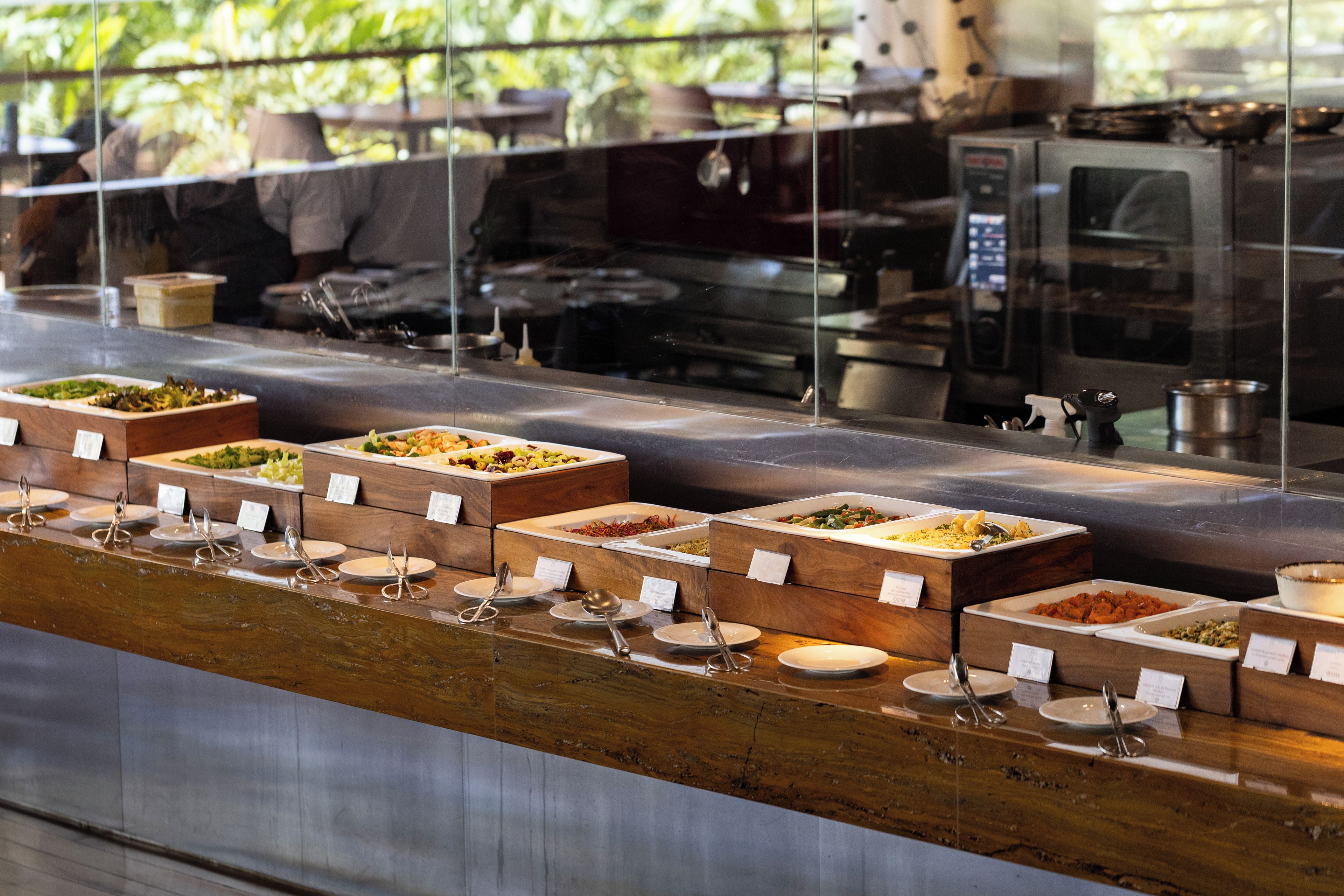 A buffet with various food stations, each with a wooden box and labeled with a dish name.