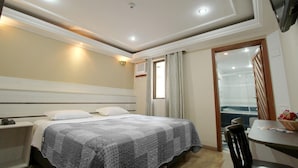 Una habitación de hotel con cama, mesita de noche y escritorio con silla.