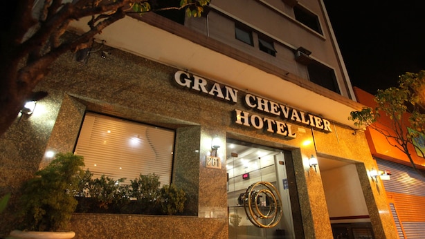 Exterior del Hotel Gran Chevalier con un gran letrero sobre la entrada, el número '261' en la fachada y un emblema circular sobre la puerta.