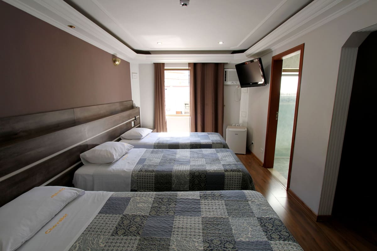Ett hotellrum med två sängar, en TV och en skjutdörr ut till balkongen.