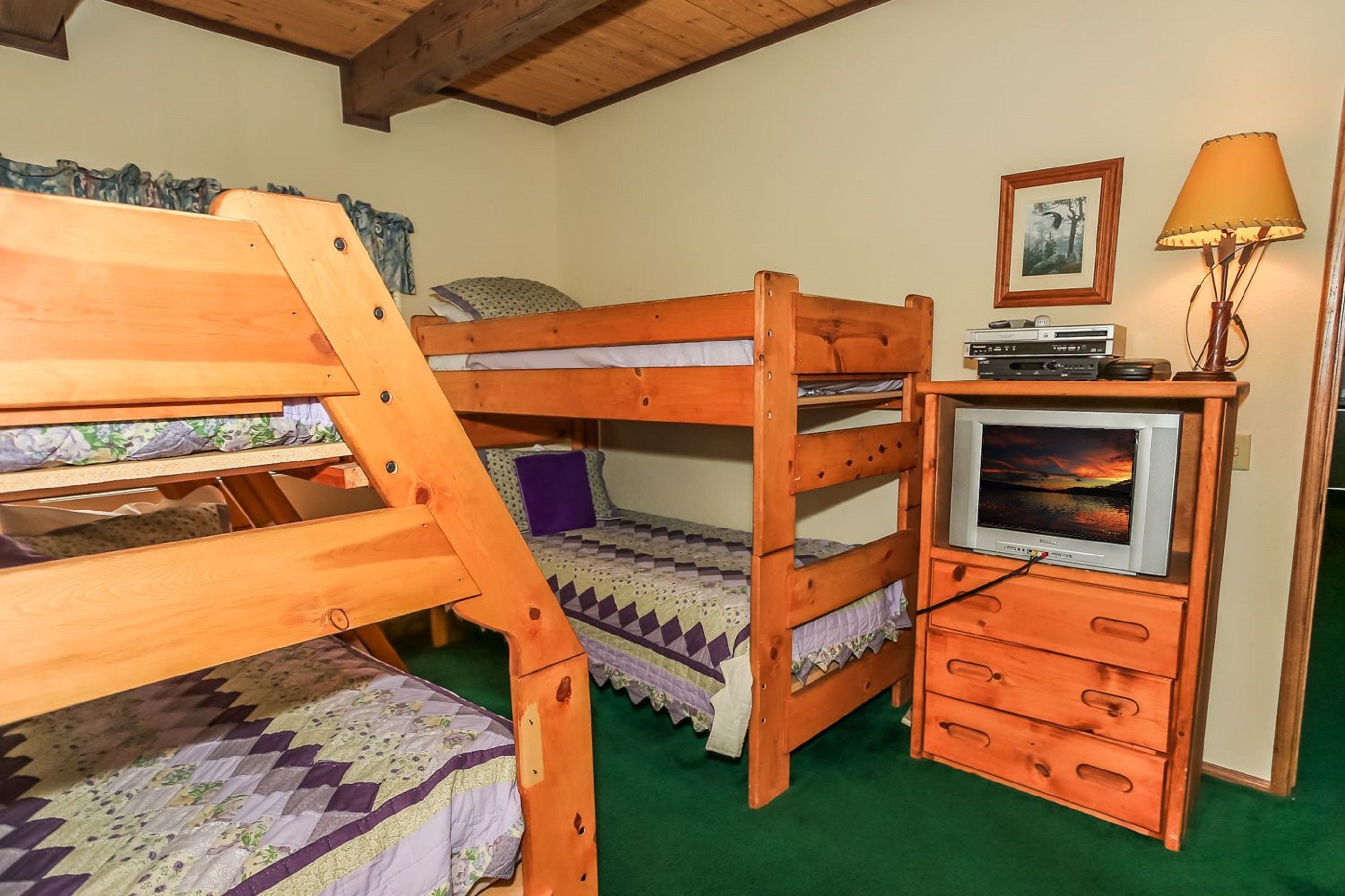A bunk bed room with a television and a lamp.