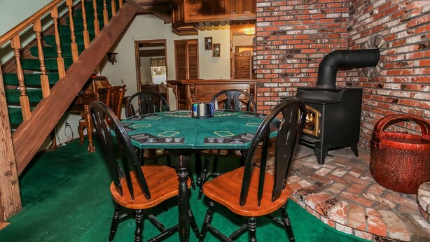 Un comedor acogedor con una escalera de madera, una pared de ladrillo y una chimenea.