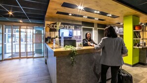 Un comptoir d’accueil avec un plan de travail en bois et une enseigne indiquant « RÉCEPTION ».