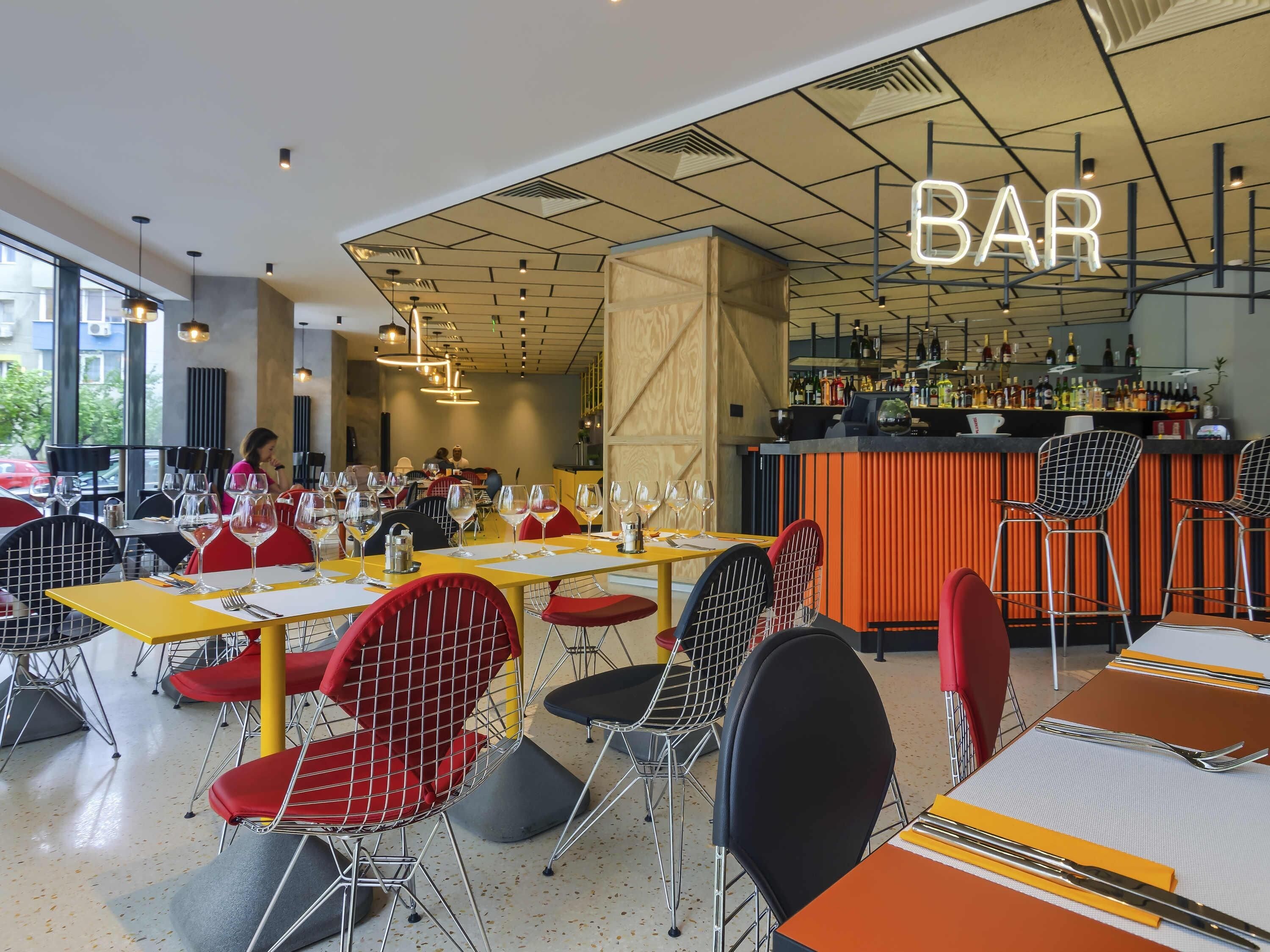 L'intérieur d'un restaurant, avec des tables, des chaises et un coin bar.