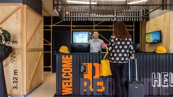 Welcome to our reception area, where a digital screen displays hotel information and a friendly welcome message is prominently displayed.