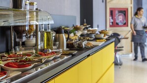 A buffet setup with various dishes and a person in the background.
