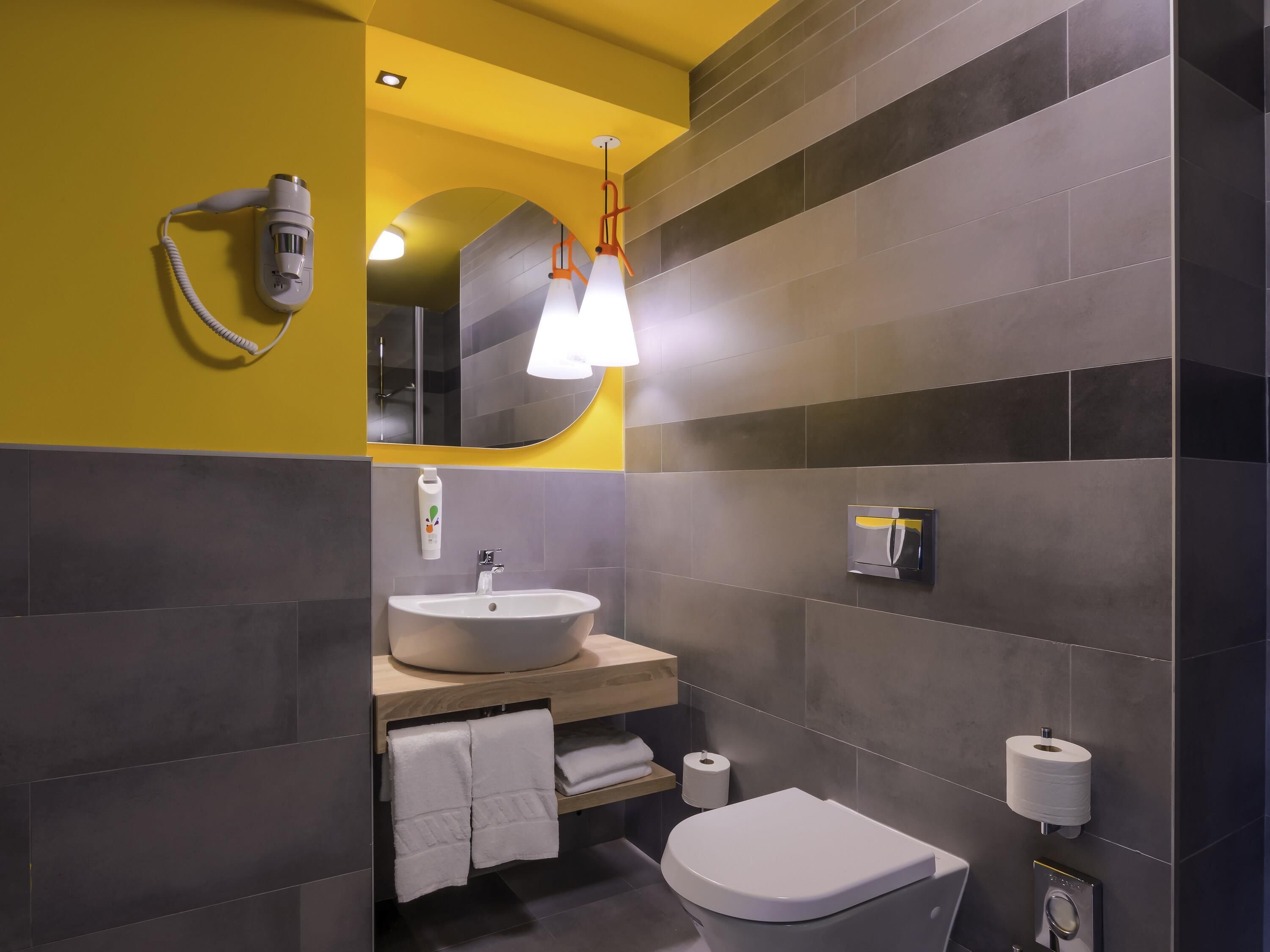 Un baño moderno con lavamanos, inodoro y toallero.