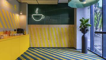 A modern interior with a striped floor, a coffee station, and a large window.