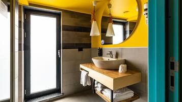 A modern bathroom with a large mirror, a sink, and a towel rack.