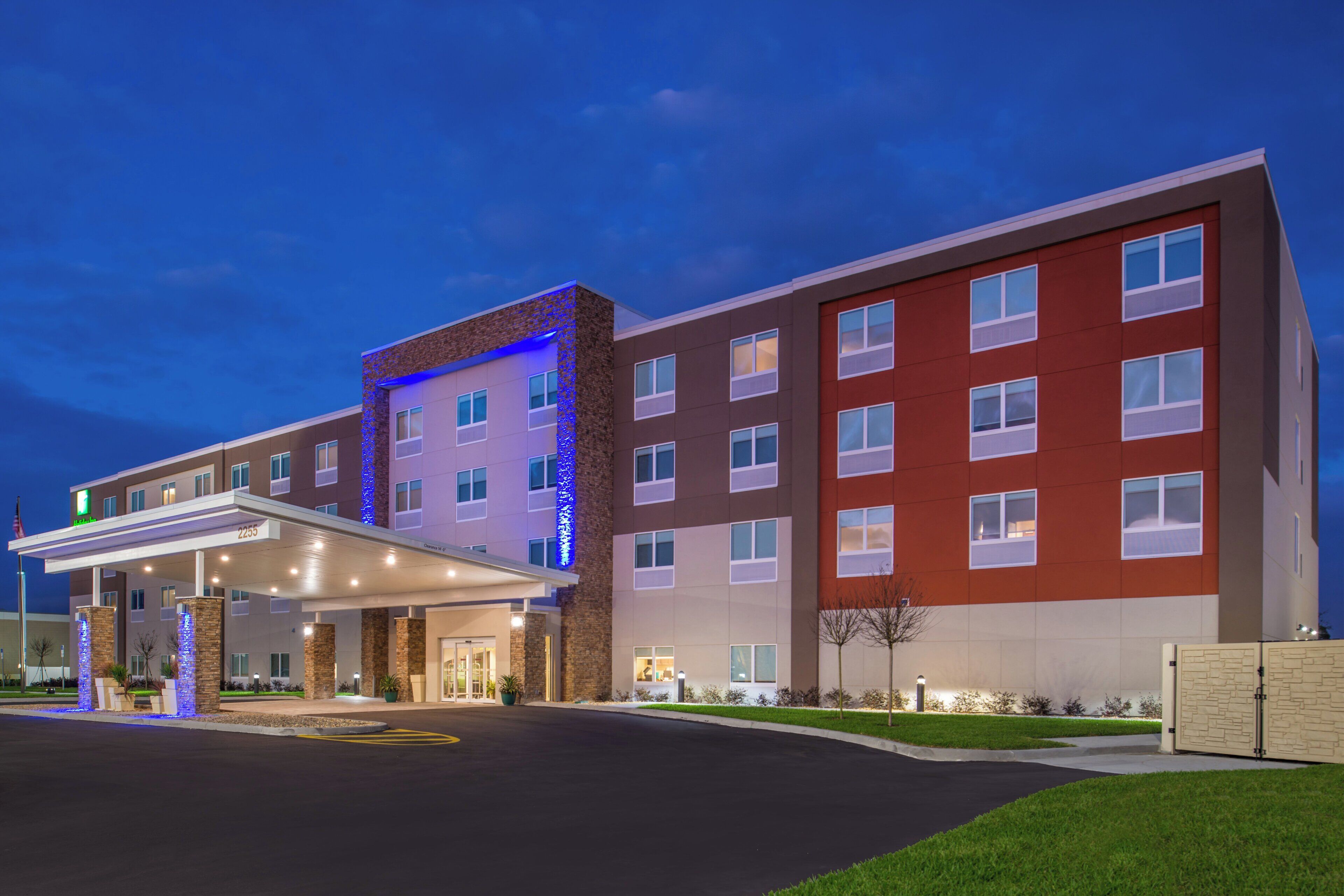 A multi-story hotel with a covered entrance and a parking lot.