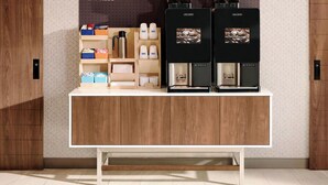 Un plan de travail de cuisine avec deux machines à café et divers ustensiles de cuisine.