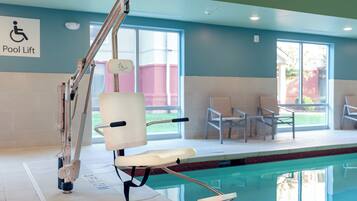 A pool lift chair by the poolside with a sign indicating a pool lift.