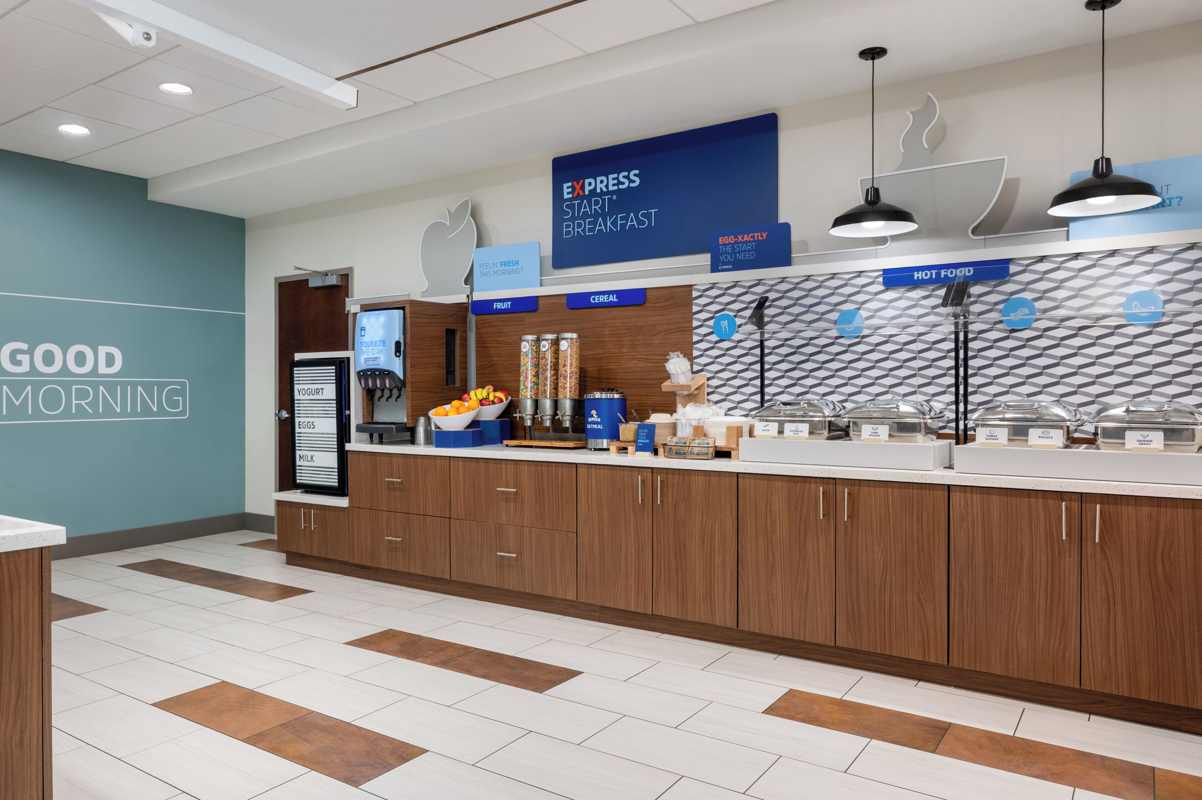 A breakfast area with labeled sections for fruit, cereal, and hot food, and a sign for Express Start Breakfast.