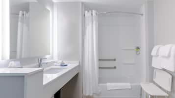 Un bagno moderno con doccia, lavandino, specchio e una panca.