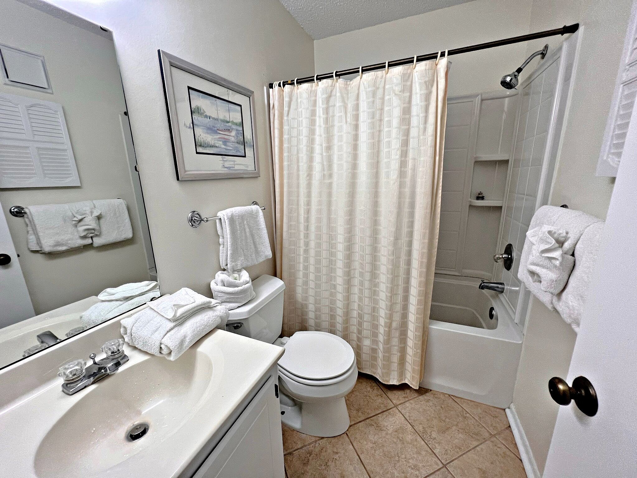A bathroom with a sink, toilet, and shower.