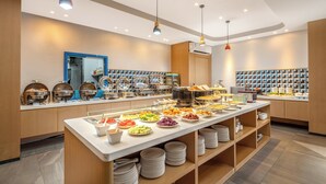 A buffet setup with various food items and a mirror on the wall. - Holiday Inn Express Sanya Bay by IHG (Sanya)