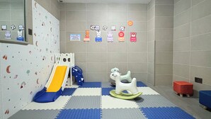 A children's play area with a slide, rocking horse, and colorful wall decorations. - Holiday Inn Express Sanya Bay by IHG (Sanya)