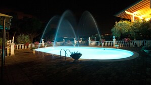 A nighttime swimming pool with three water jets. - La Villa Del Colle (Monte San Giovanni Campano)