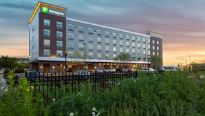 A Holiday Inn hotel with a modern design, featuring a brick facade and multiple windows. - Holiday Inn Boston Logan Airport - Chelsea by IHG (Chelsea)